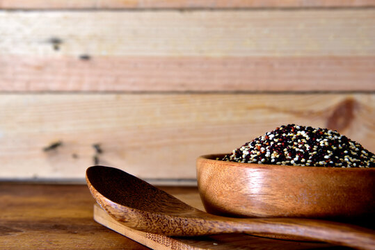 Dry white and black quinoa in a wooden bowl