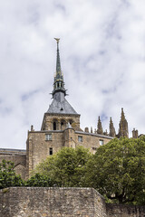 Fototapeta premium Abbey Mont Saint-Michel (VII century) at rocky tidal island in Normandy - one of most visited tourist sites in France. Normandy, Northern France, Europe.