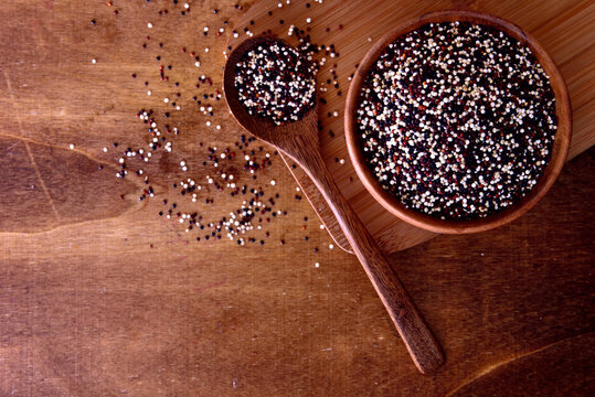 Dry white and black quinoa in a wooden bowl