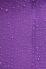 Raindrops on purple metal surface