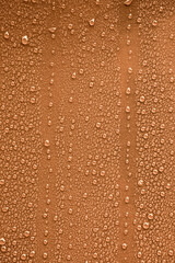 Raindrops on orange metal surface