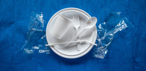 Vaerios utensilios de plástico blanco desechable sobre un fondo de color azul