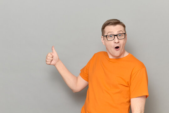 Portrait of amazed impressed man raising thumb up in approval gesture