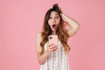 Image of shocked cute woman using cellphone and expressing surprise