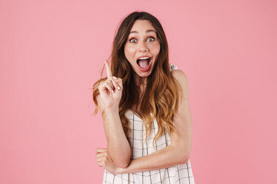 Image of excited woman expressing surprise and pointing finger upward