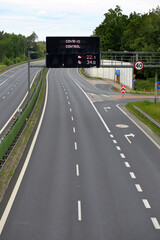 Empty highway and information board with covid-19 control inscription