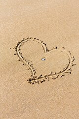 Fototapeta na wymiar Heart drawn on beach sand, summer love.