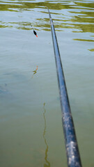 Fishing rod, fishing pole with a cork or float on the river.