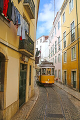 Historic yellow tram against old town streets, part of the tramway network since 1873, Lisbon, capital city of Portugal.