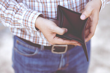 Empty wallet (no money) in the hands of an man. Cost control expenses poverty in concept. Leave space to write descriptive text.