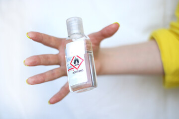Hand is catching bottle with liquid sanitizer. Fight against  viruses and illnesses