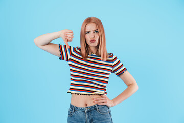 Image of displeased beautiful girl showing thumbs down