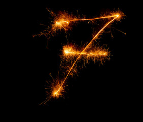 number seven written with a sparkler on a black background