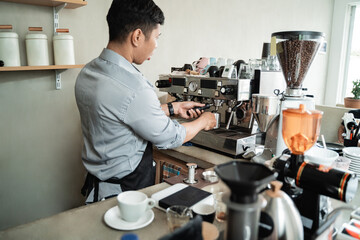 Barista makes coffee with a coffee maker machine for customers