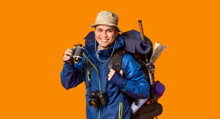 Obraz premium Happy backpacker enjoying his journey, holding binoculars