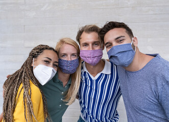 Portrait of happy young people smiling - Multiracial friends wearing protective face masks - Focus...