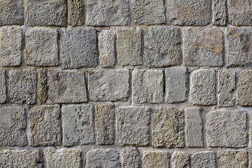 Unique texture of an ancient wall made of uneven bricks close-up