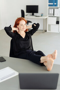Woman resting in office with her feet up on desk