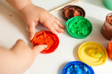 Close up of colored hand print on white background. Ideas for drawing with finger paints. Finger painting for kids. Little girl painting by finger hand paint color. Children development concept.