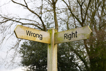 A wooden signpost pointing Wrong and Right