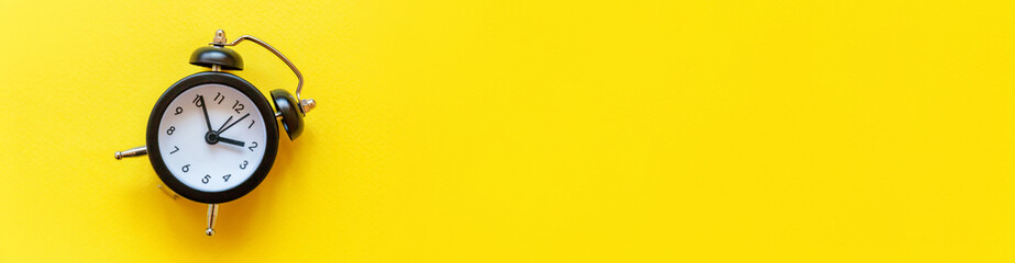 Simply minimal design ringing twin bell vintage classic alarm clock Isolated on yellow background....