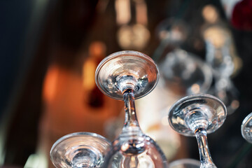Close up inverted glass goblets in a bar. Inverted glasses and wine glasses on the table,Crystal wide glass upside down arrangement, Inverted wine glasses on a black background, Cafe, A restaurant.