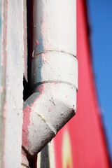 altes weisses Wasserrohr aus Metall  , bunter Hintergrund, bunte Mauer