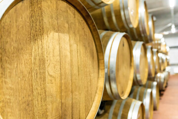 Selective focus. Row of Large French Oak Red Wine Barrels in a Modern Wine Warehouse