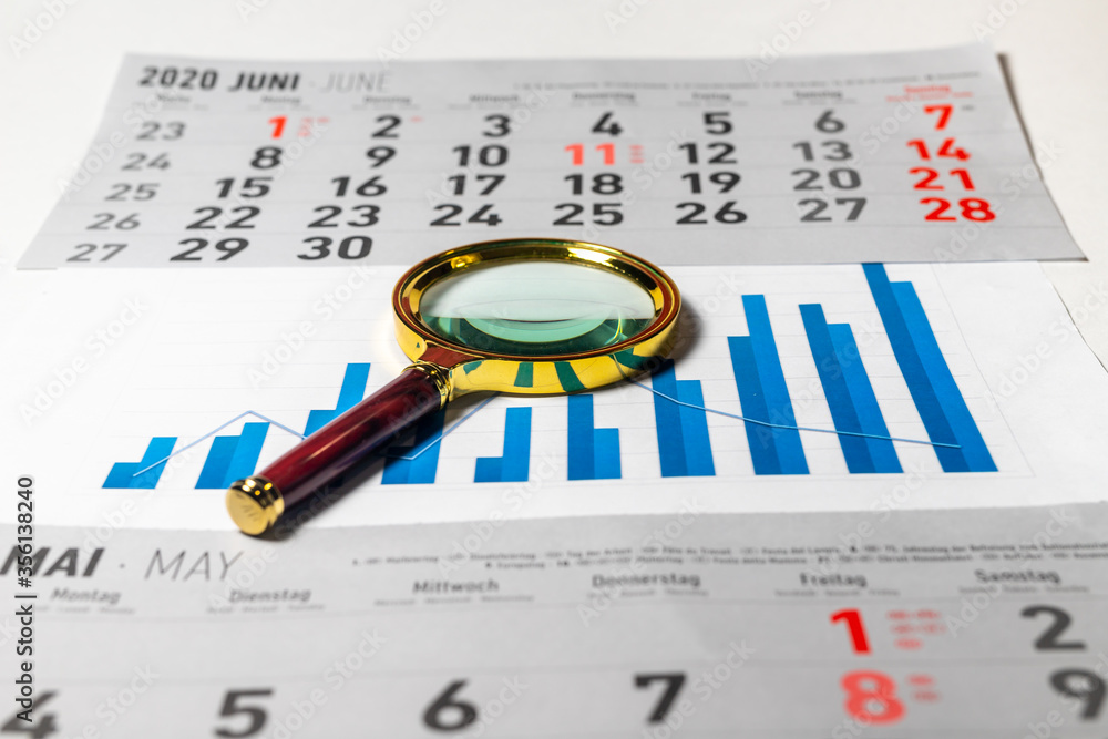 Poster golden magnifier on chart graph diagram of growth in blue color colour with calendar sheets on blue 