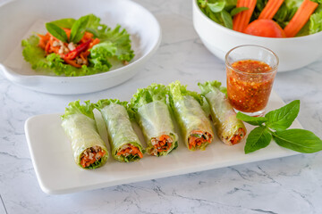 Fresh rice sheet spring rolls with minced pork, vegetable and spicy sauce as traditional Asian healthy