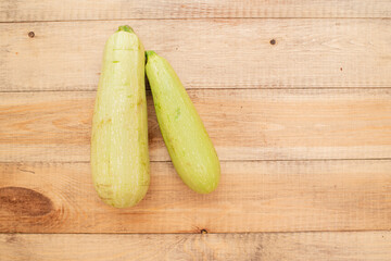 Large ripe and juicy zucchini on a wooden table. Healthy diet