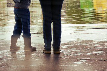 A girl and her mother wait out the rain at the exit of the metro