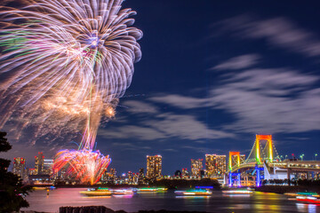 Odaiba, Tokyo, Beautiful and colorful firework with rainbow bridge and Tokyo city night view, event every summer and winter. This set firework presented in yellow orange and purple light. 