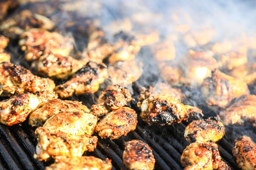 Spicy marinated chicken wings and legs grilling on a summer barbecue.Detailed view of grilled chicken