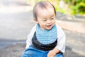 Fototapeta premium 外で砂遊びで砂を触って上機嫌の子供