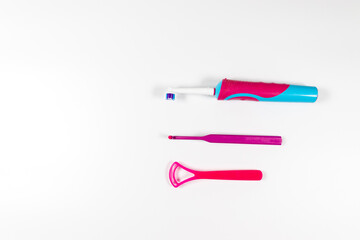 Ultrasonic pink toothbrush and dental hygiene products on a grey background. Dental products for brush teeth, healthy teeth care and oral hygiene