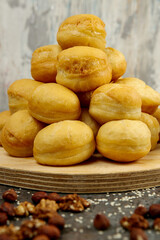 Baursaki is a traditional pastry of national oriental cuisine. On a wooden plate, on a gray textured background