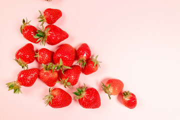 Top view composition of organic delicious strawberry berries with copyspace on pink background, minimal composition