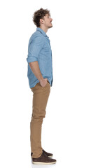Fototapeta premium side view of casual model holding hands in pockets