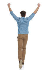 back view of enthusiastic guy holding arms in the air