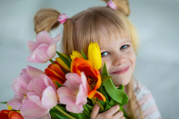 Obraz na płótnie Canvas baby in pajamas with a bouquet of tulips