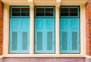 Old blue turquoise vintage wooden shutter windows with brick wall