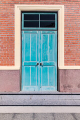 Old blue turquoise wooden vintage door with brick wall