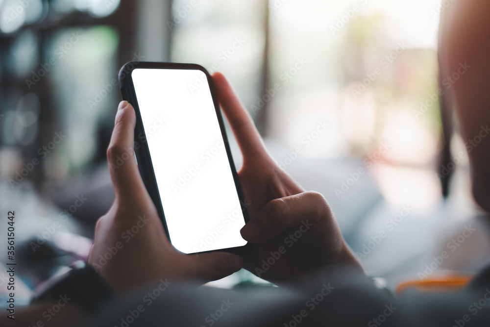 Poster woman's hand holding black mobile phone with blank desktop screen. empty screen for mockup image or 