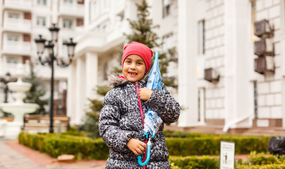 little girl with umbrella on the street in the city