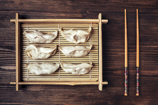 Top View Of Bamboo Tray With Gyozas And Chopsticks