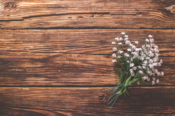 Flat lay of a bouquet of flowers against a rustic wood table