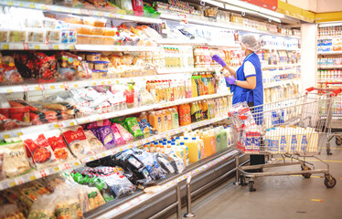 he supermarket worker arranging  frozen food at refrigerator ,preparing of foods  for the wholesale...