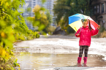 little girl with umbrella on the street in the city