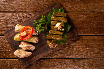 Arabic food. Appetizing cabbage rolls and Rice and mint wrapped in grape vine leaves on wood background